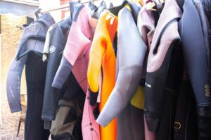 ラックに並ぶカラフルなウェットスーツ｜ブラックフライデー2026でサーフィン用品を買う前に知っておきたい値引きの傾向