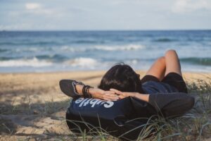 海へ向かうサーファーと防水バッグ