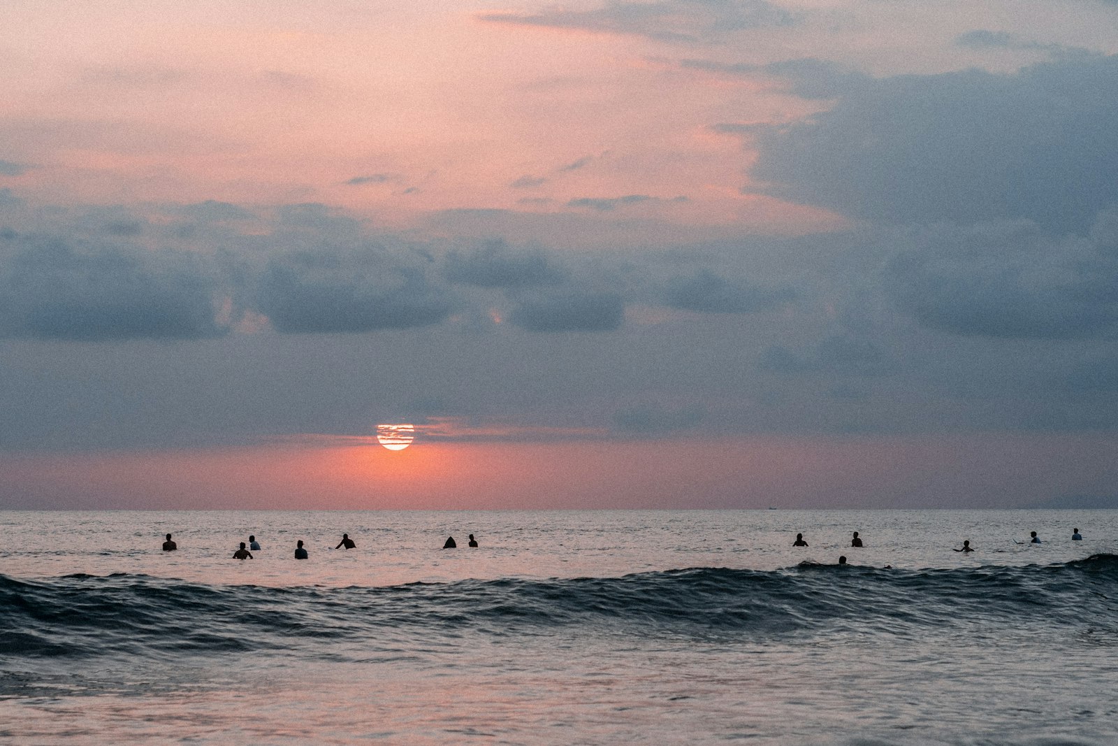 冬の夜明けの海に浮かぶ大勢のサーファー。冬サーフィンでも混雑する日はある