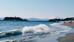 国府の浜のような遠浅のビーチブレイクに集まるサーファーたち