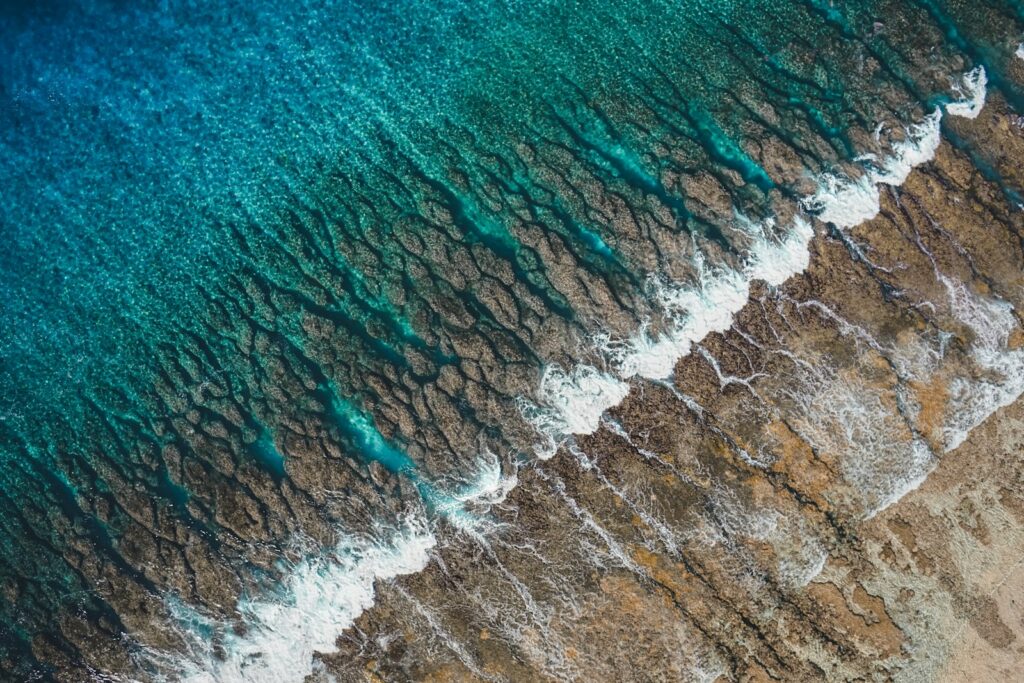沖縄のリーフに北うねりが割れる様子を空撮で捉えた海岸線