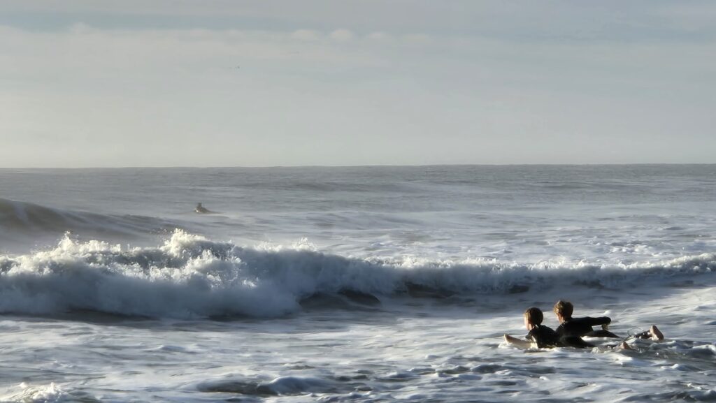 セット波に向かってラインナップに並ぶサーファーたち