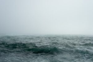 海上に発達した嵐の雲と荒れる海面。台風の進路予想を読み解くイメージ