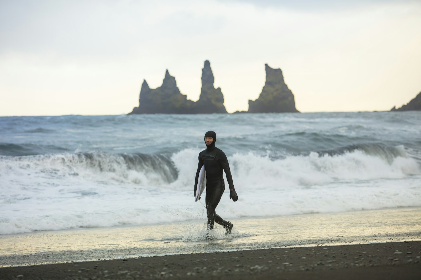 フルスーツで海へ向かうサーファー。秋はタッパーから一気に生地が厚くなる